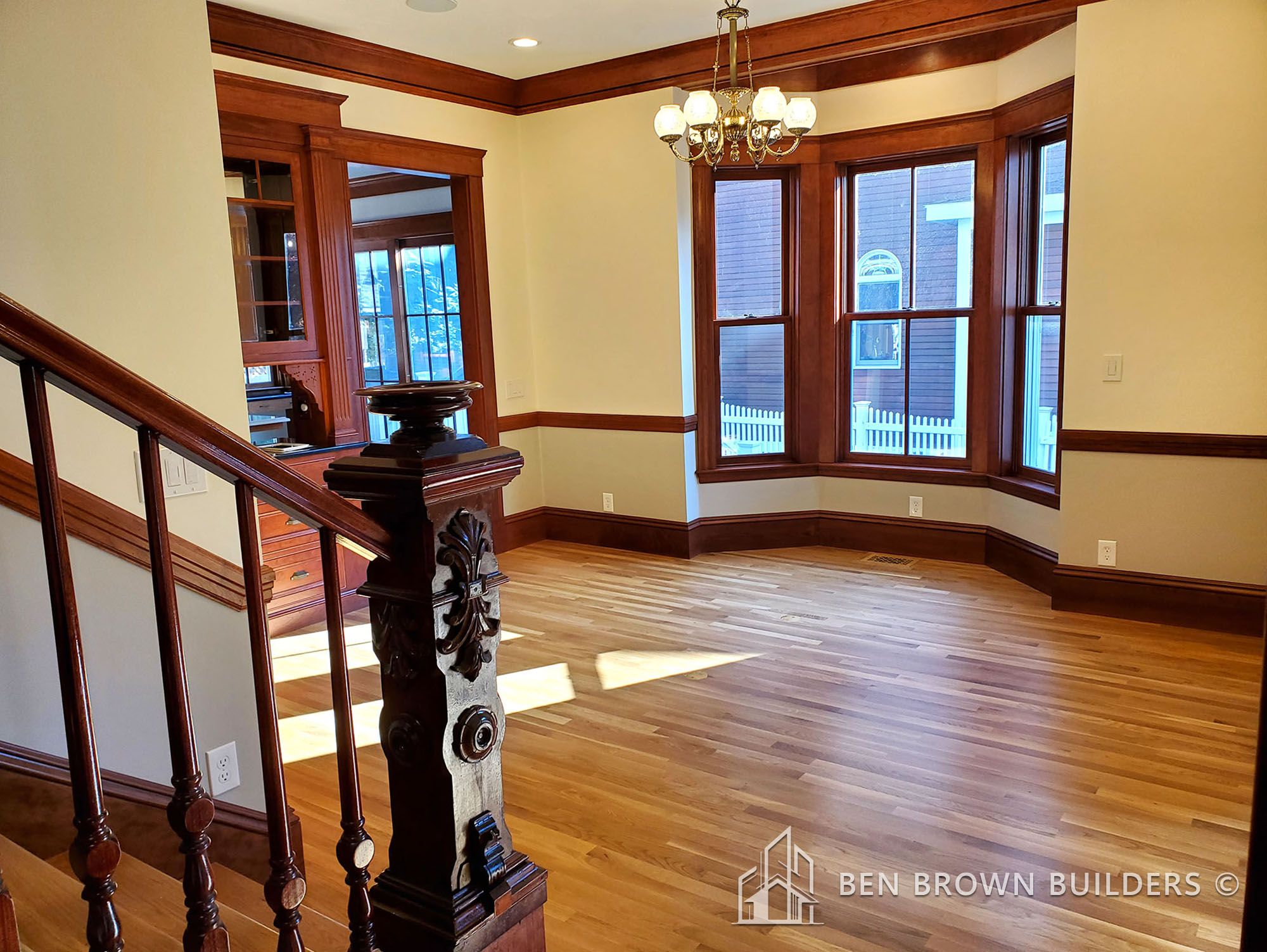 Elegant interior of a home with gleaming hardwood floors and rich wooden trim around windows and baseboards